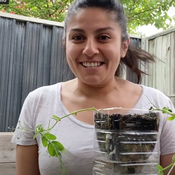 Christina smiles, holding her self-watering planter.
