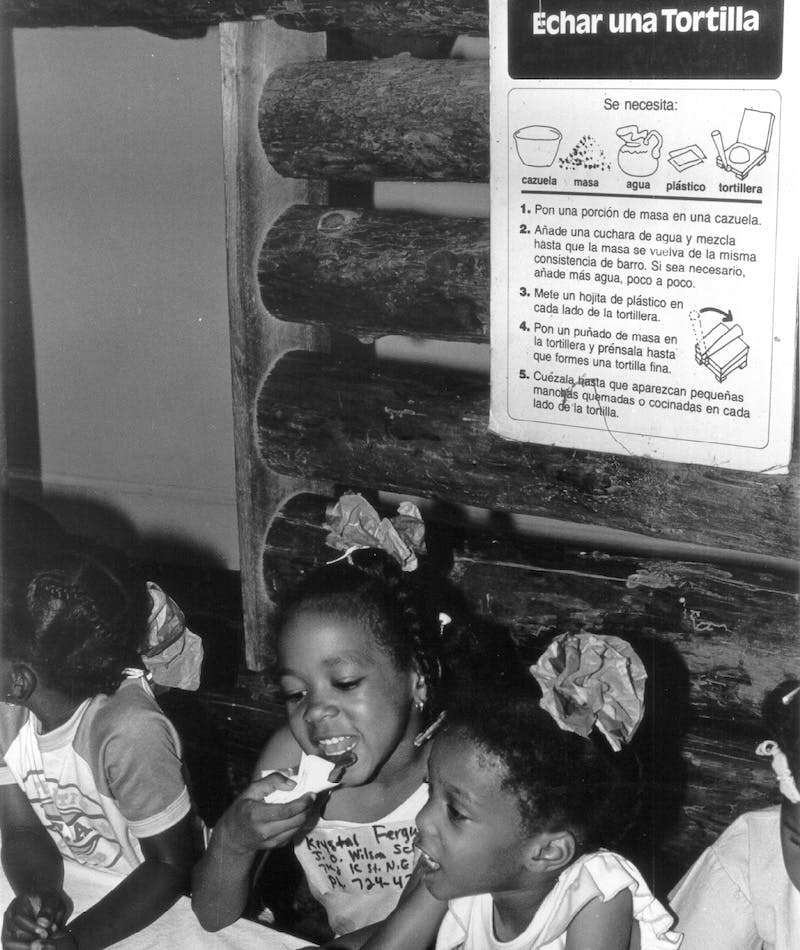 Children learning how to make tortillas in the Mexico Exhibit from Capital Children's Museum