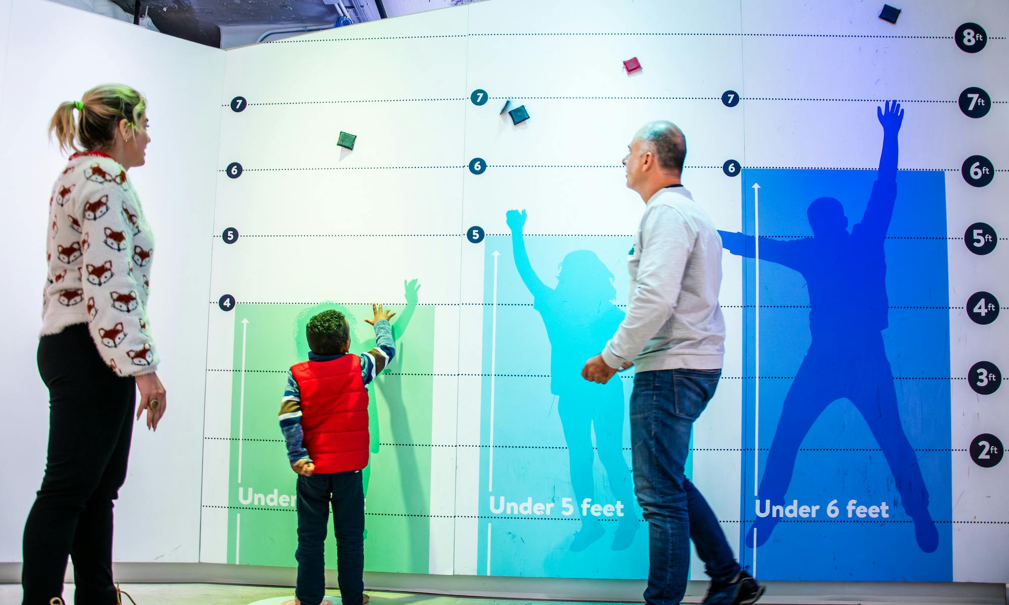 Family at the New Heights jump wall in the Data Science Alley exhibit