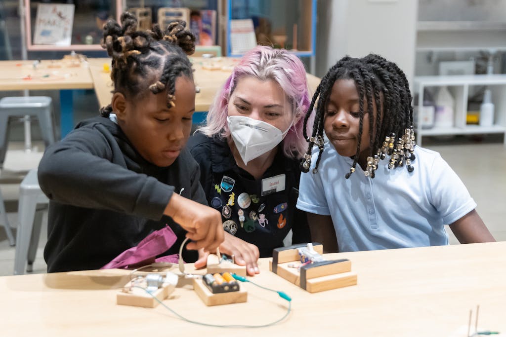 Two young girls working on circuit blocks with a Museum educator in the Tinkerers Studio