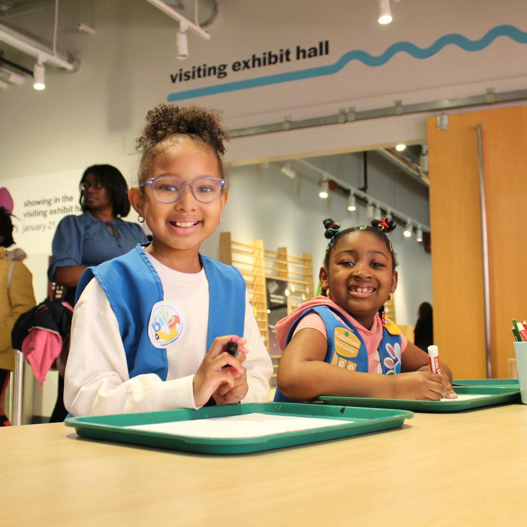 Two girl scouts participating in an activity at Girl Scouts Day.