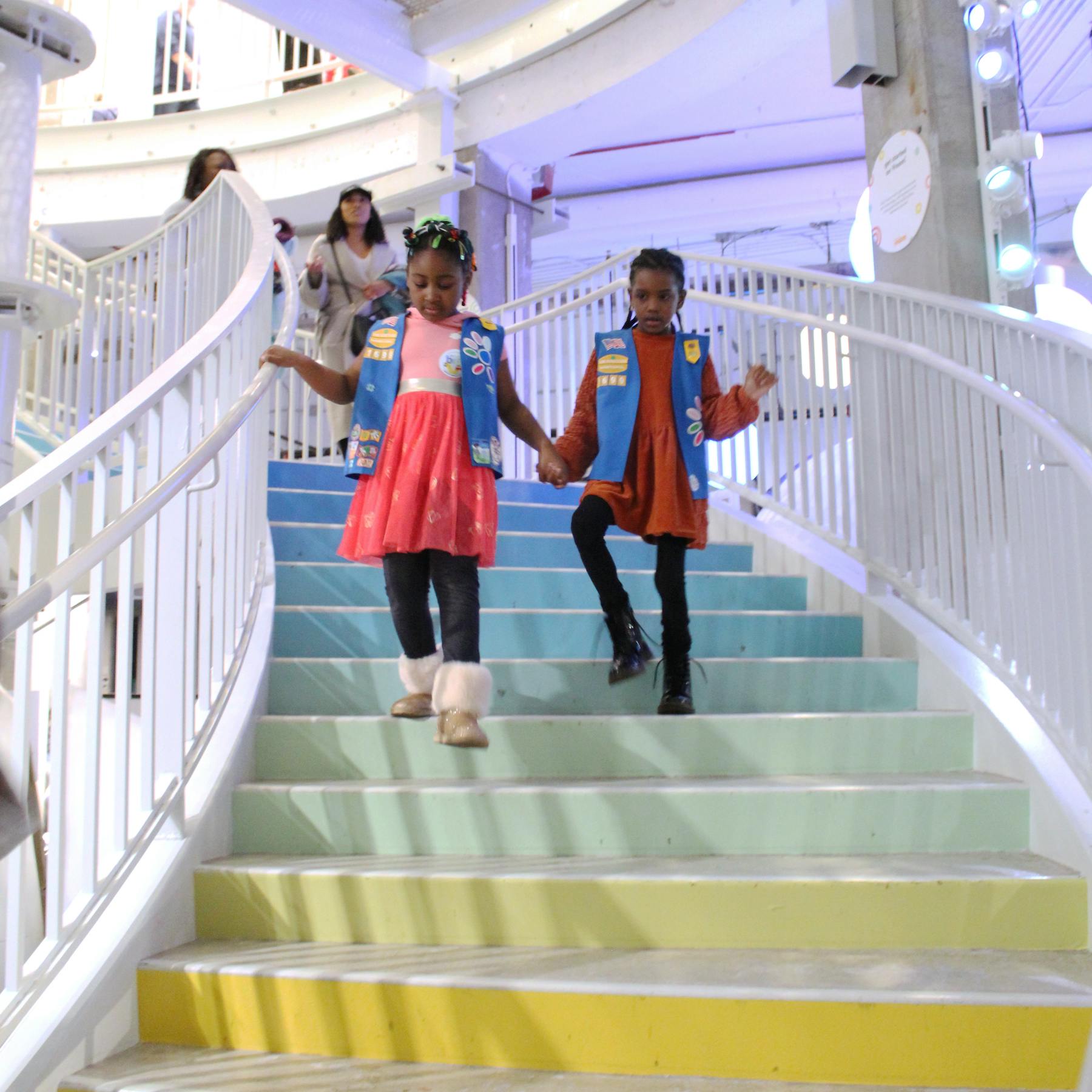 Two girl scouts entering the Museum on the rainbow stairs